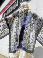 Person wearing a patterned kimono-style garment with a blurred background