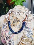 displayed on a paper Mache form, layered with a long shell necklace