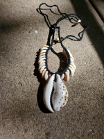 Adjustable unisex Necklace with shell pendants on a textured surface