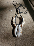 Adjustable unisex Necklace with shell pendants on a textured surface