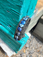 Bracelet with blue lapis lazuli gemstones on a turquoise wooden surface