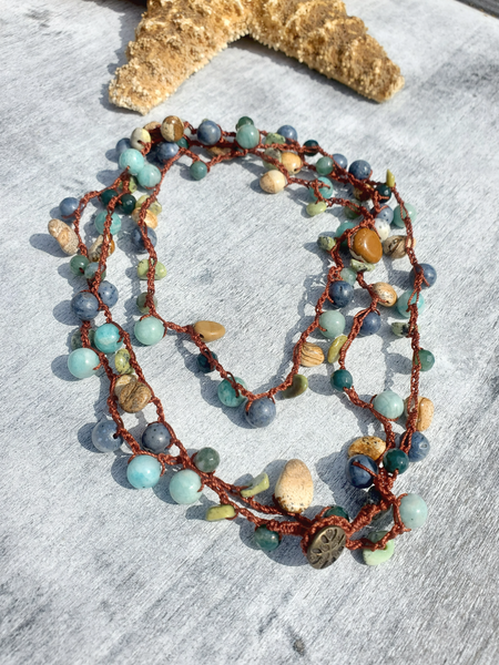 long layering necklace with beads on a textured surface