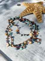 Necklace with multicolored beads on a textured surface with a starfish