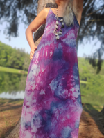 Person wearing a tie-dye dress with a blurred natural background