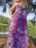 Person wearing a tie-dye dress with a blurred natural background