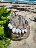 Hemp and moon shells necklace on a sandy beach