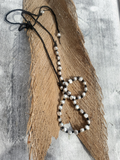 knotted pearl necklace on a wooden surface