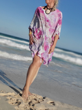 Person wearing a pink and purple dress on a beach