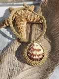 Crocheted necklace; with shell design on a wooden surface.