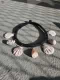 7 different sea shells attached with brass rings to the rope choker