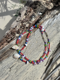 Colorful beaded necklaces with shell elements on a wooden surface