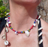 Necklace with shells and beads worn by a person outdoors