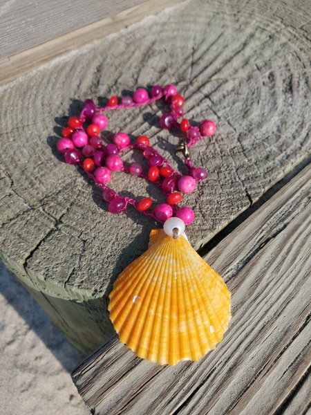 yellwo shell pendant with a white pearl accent, on a crocheted pink-red gemstone beads chain