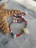 Colorful beaded bracelet with shells on a starfish and marble surface