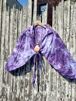 Purple velvet top with a large orange pendant on a wooden background