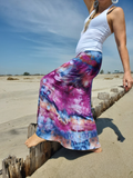 Person wearing a colorful tie-dye skirt on a beach