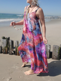 Woman in a colorful dress standing on a beach with ocean in the background