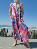 Person wearing a colorful tie-dye dress on a beach