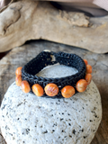 woven black leather bracelet with orange spiny oyster shell beads