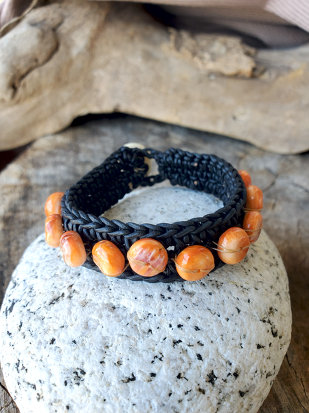 woven black leather bracelet with orange spiny oyster shell beads