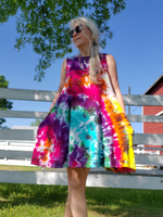 I'm modeling a size small sleeveless swing dress. This is a frontal selfie, my hands are in my pockets, legs crossed, sunglasses. The dress is very colorful; I dyed it in my Rainbow Galaxy colors; yellow-oj-pink-purple-green-jade, and a bit of black plashed around.