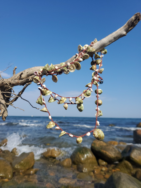 crocheted on a nylon thread, sliced green turbo shell and puka shells necklace. 52' long