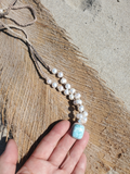 The pendant is on my fingers, showing the ratio/size of this white pearls necklace