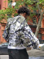 A somewhat side way shot of the jacket, front open, Daniel  has his hands in the pockets. Photos were taken on a Brooklyn Street.