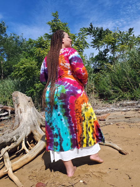 Ana on the beach wearing my long ribbed rayon jersey basic cardigan with pockets and extra long sleeves with thumbholes. The hand dyed rainbow colors are super bright! This photo is showing Ana's back.