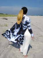 My daughter Stephanie is modeling this open midi cardigan. We are at the beach. She has white pants and a tank top, and a straw hat hanging on her back.