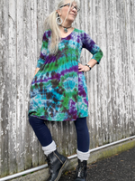 Modeled front of our fence; I'm wearing a size small ¾ sleeve babydoll mini dress with pockets. the originally heather grey garment hand dyed  in my Northern Lights combo; purple-green-jade with a hint of black dye.