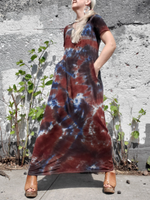 Ankle length slightly A-line tie dye dress with V-neck & pockets. earthy tie dye; brown-black. An almost frontal photo - I have my hands in the pockets